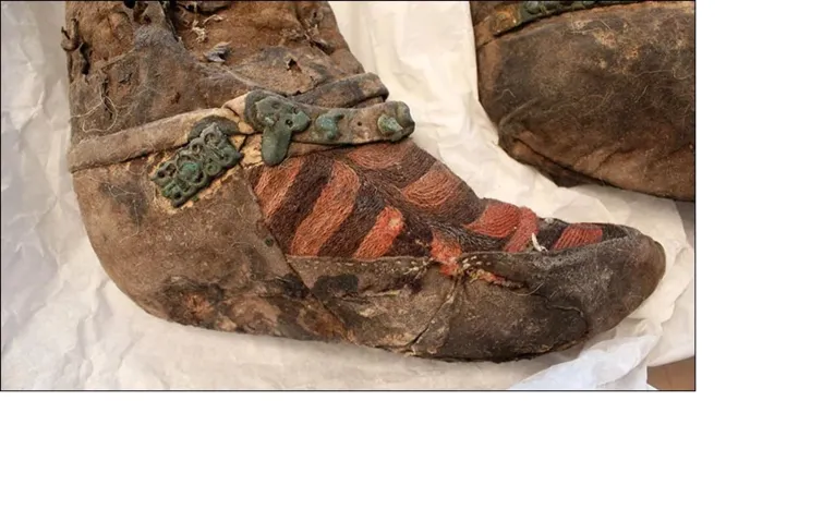 Par de botas de feltro e couro, com bordado e ferragens no tornozelo. A semelhança das listras com o “design” dos tênis Adidas originou o apelido “Múmia Adidas”.