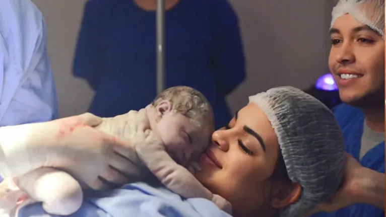 Maria Lívia nos braços da mãe e acompanhada também do pai