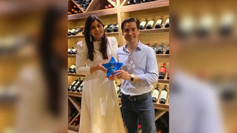 Os sócios Mayara Hamad e Rodrigo Aguilera recebendo o Troféu Estrela Azul