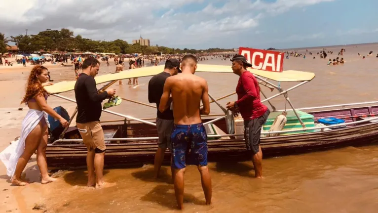 Casal Samuel e Ingra se aproximam ao ver a lancha do açaí chegar e garantir o litro deles