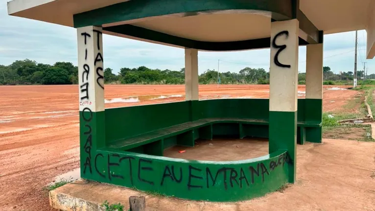 Parada de ônibus com pichação informando que para entrar no local, é preciso tirar o capacete