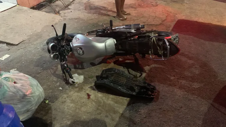 A moto da vítima ficou jogada na rua após ela ser ferida pelos tiros.