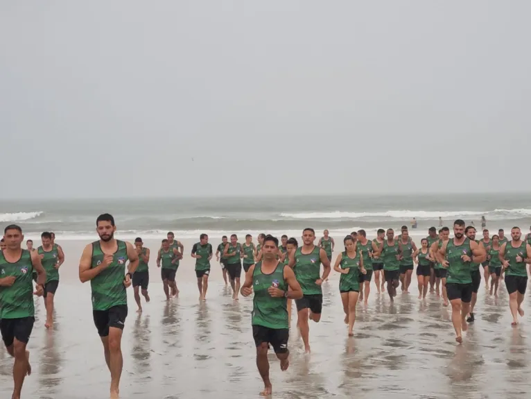 Árbitros e assistentes em atividade física na praia de Atalaia, em Salinas