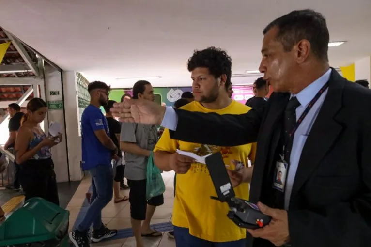 Candidato recebe orientação de um dos fiscais sobre o seu local de prova