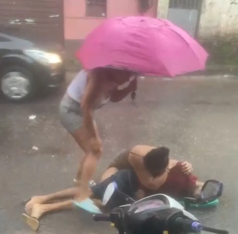 Familiares tentam proteger o corpo do ente querido sem vida da chuva