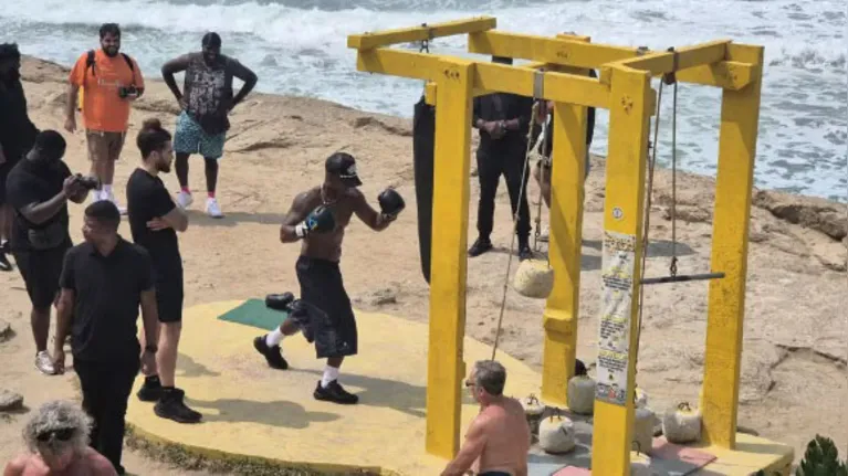 Ne-Yo em treino de boxe na praia do Arpoador, sendo assistido por treinador e fãs