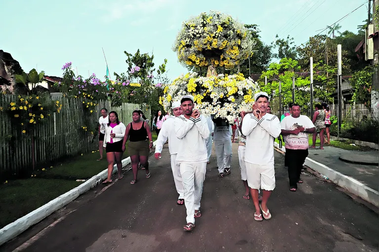 A imagem da padroeira do local faz o caminho pelo rio de águas escuras em uma canoa, puxada pelos marinheiros, que usam figurino a caráter, tradicional dos puxadores.