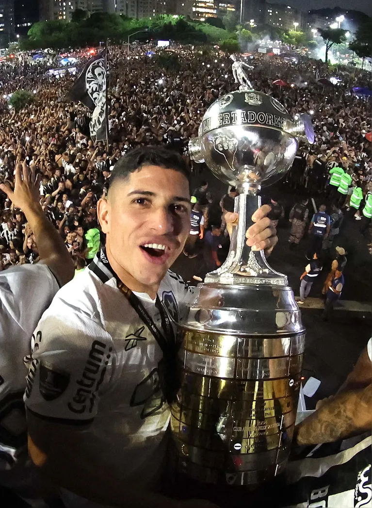 Savarino com a taça da Libertadores com a torcida ao fundo