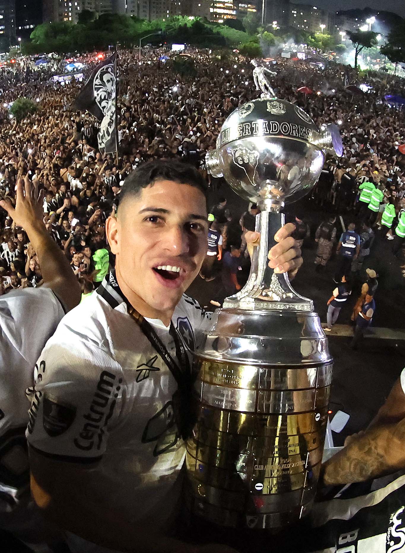 Savarino com a taça da Libertadores com a torcida ao fundo