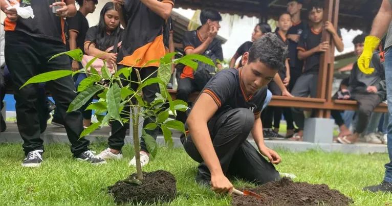 Uma das ações da programação escolar envolveu os alunos colocando as mãos na terra para plantar mudas e contribuir ativamente com a preservação ambiental.