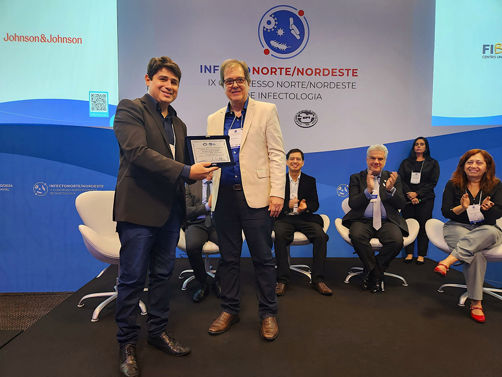 Seu filho Victor Athayde recebendo homenagem feita a ela no IX Congresso Norte/Nordeste de Infectologia