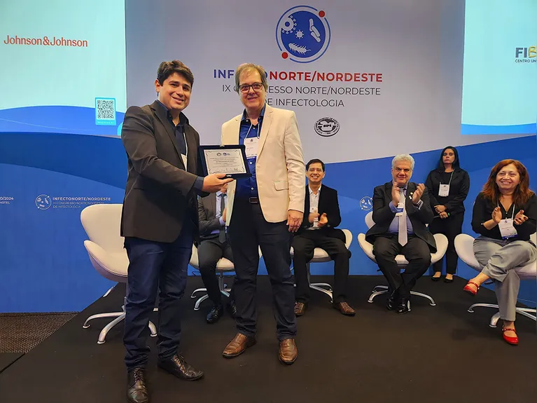 Seu filho Victor Athayde recebendo homenagem feita a ela no IX Congresso Norte/Nordeste de Infectologia