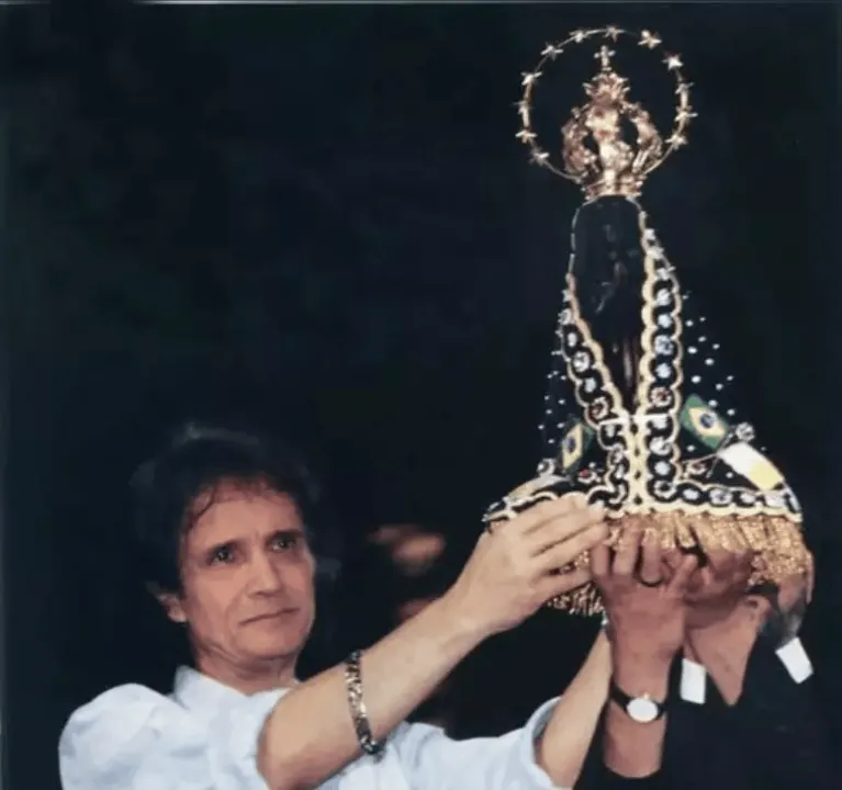 O cantor com uma imagem de Nossa Senhora Aparecida.