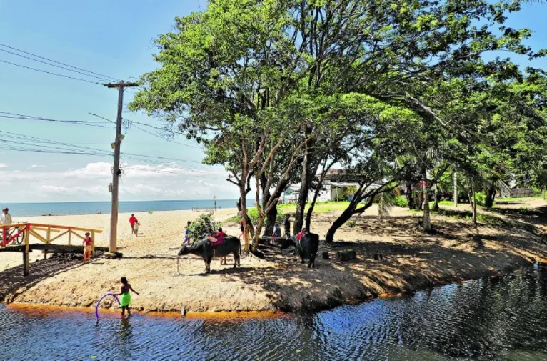 De um lado a praia, do outro o igarapé.