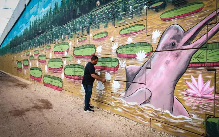 O artista Jeferson Cardoso dá os últimos retoques em sua obra inspirada na fauna e flora amazônicas.