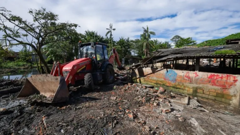 Retroescavadeira derruba estrutura irregular no canal do Mata Fome, em Belém, durante ação de desobstrução.