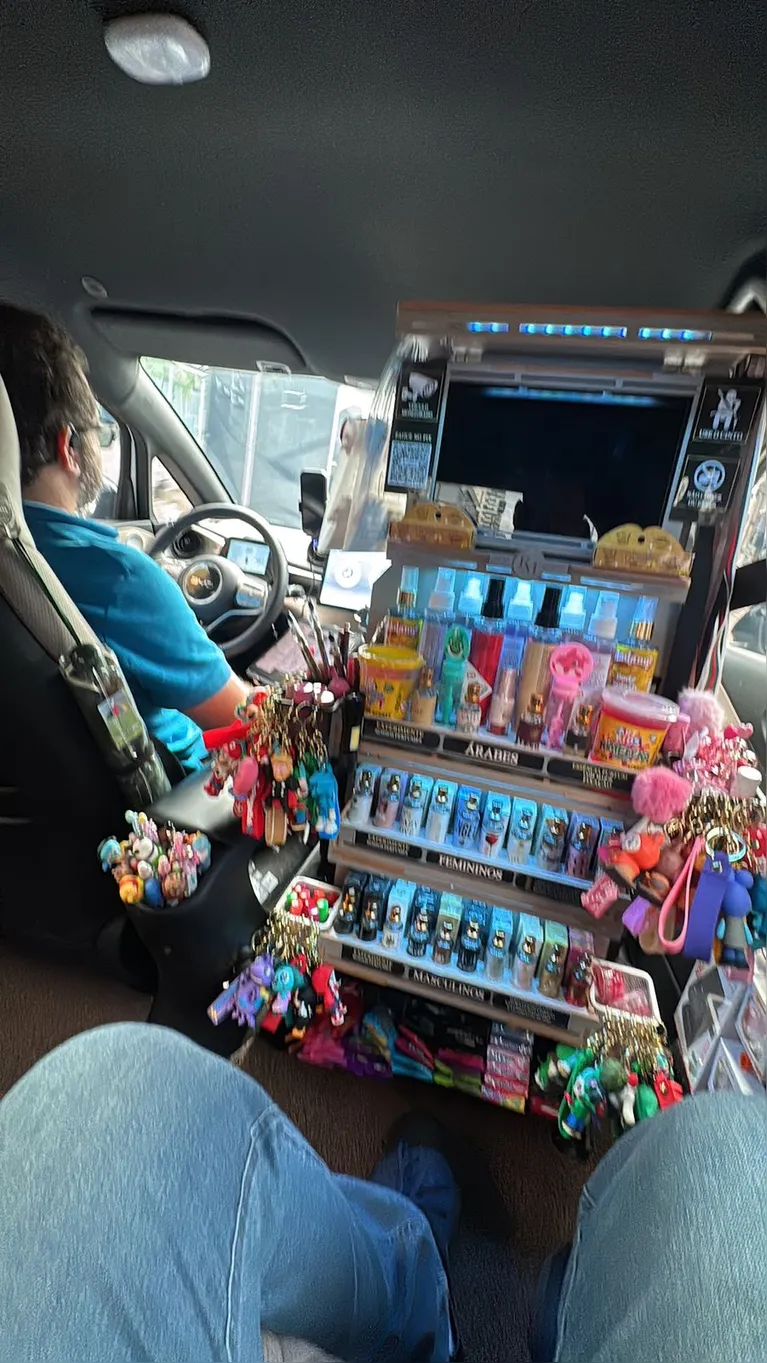 Na imagem registrada, é possível ver uma prateleira adaptada com itens variados, como acessórios, bombons e cosméticos.