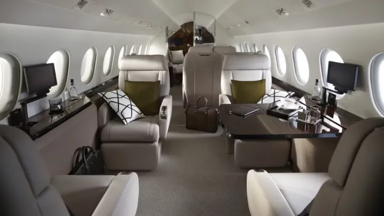 Visão geral da cabine do Falcon 900LX, projetada para oferecer conforto e sofisticação, com capacidade para até 14 passageiros, dependendo da configuração escolhida.