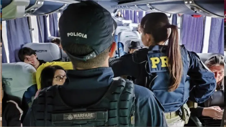 Policiais rodoviários federais orientam passageiros no interior de ônibus intermunicipal durante ação da Operação Alerta Lilás, em Marabá (PA).