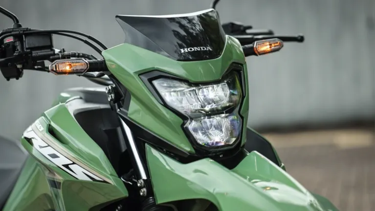 A Honda NXR160 Bros 2027 ganha piscas em LED, pisca-alerta, luzes de posição integradas ao farol e lampejador no punho esquerdo.