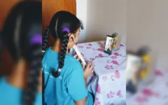 Aluna Catarina Santiago tendo aula virtual de flauta. 