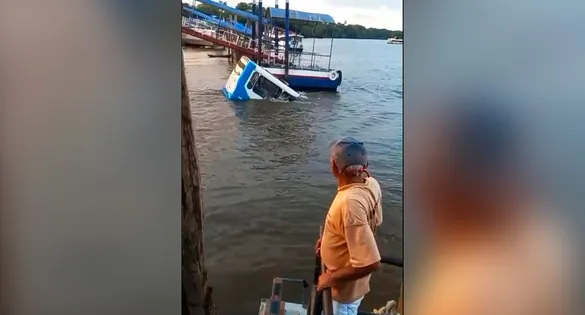 Veículo parcialmente submerso nas águas do rio logo após a queda; registro mostra o momento dramático em que os sobreviventes usam as janelas para escapar.